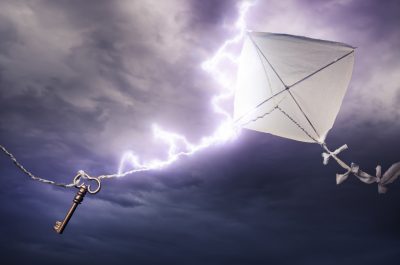 Conceptual image of kite with key being stuck by lightning