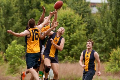 Players Jump To Catch Ball In Australian Rules Football Game